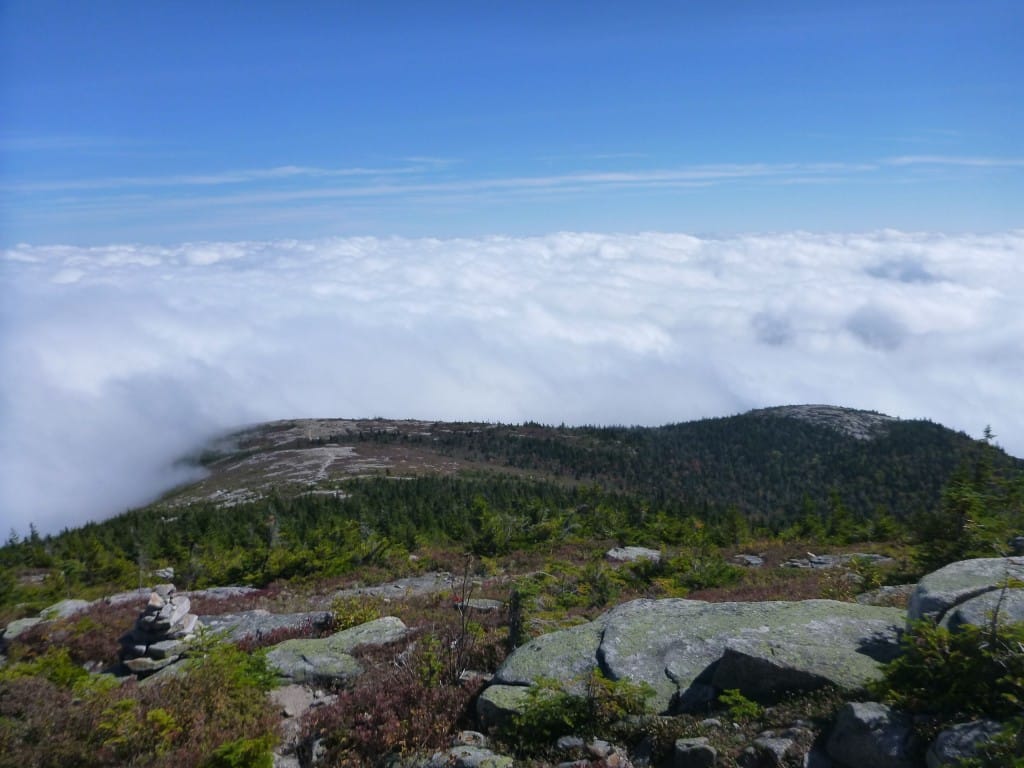 A sea of clouds settle into the valley below an exposed ridgeline.