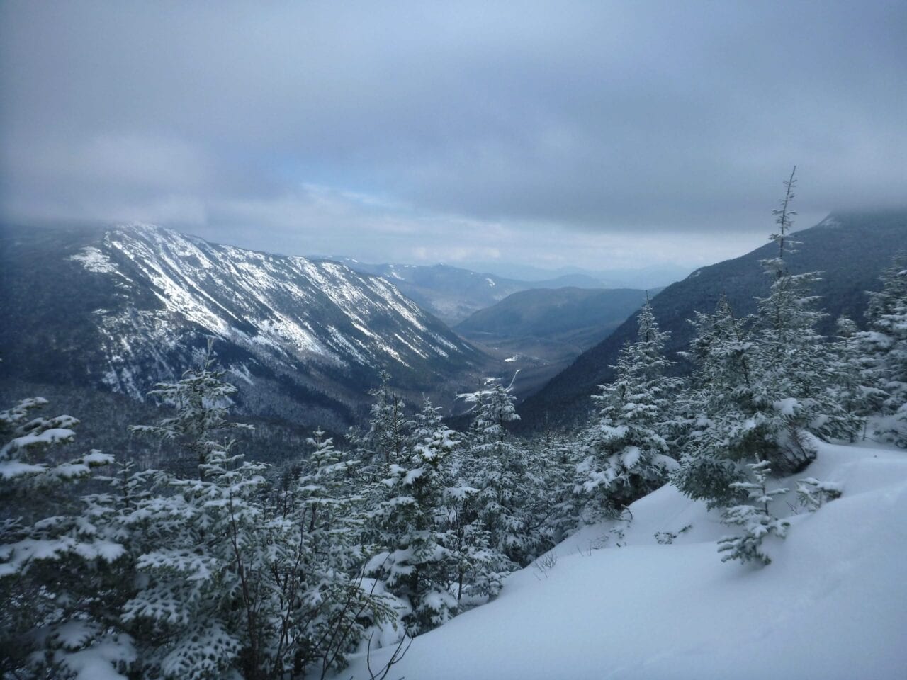 clouds sit over a snowy mountain range.