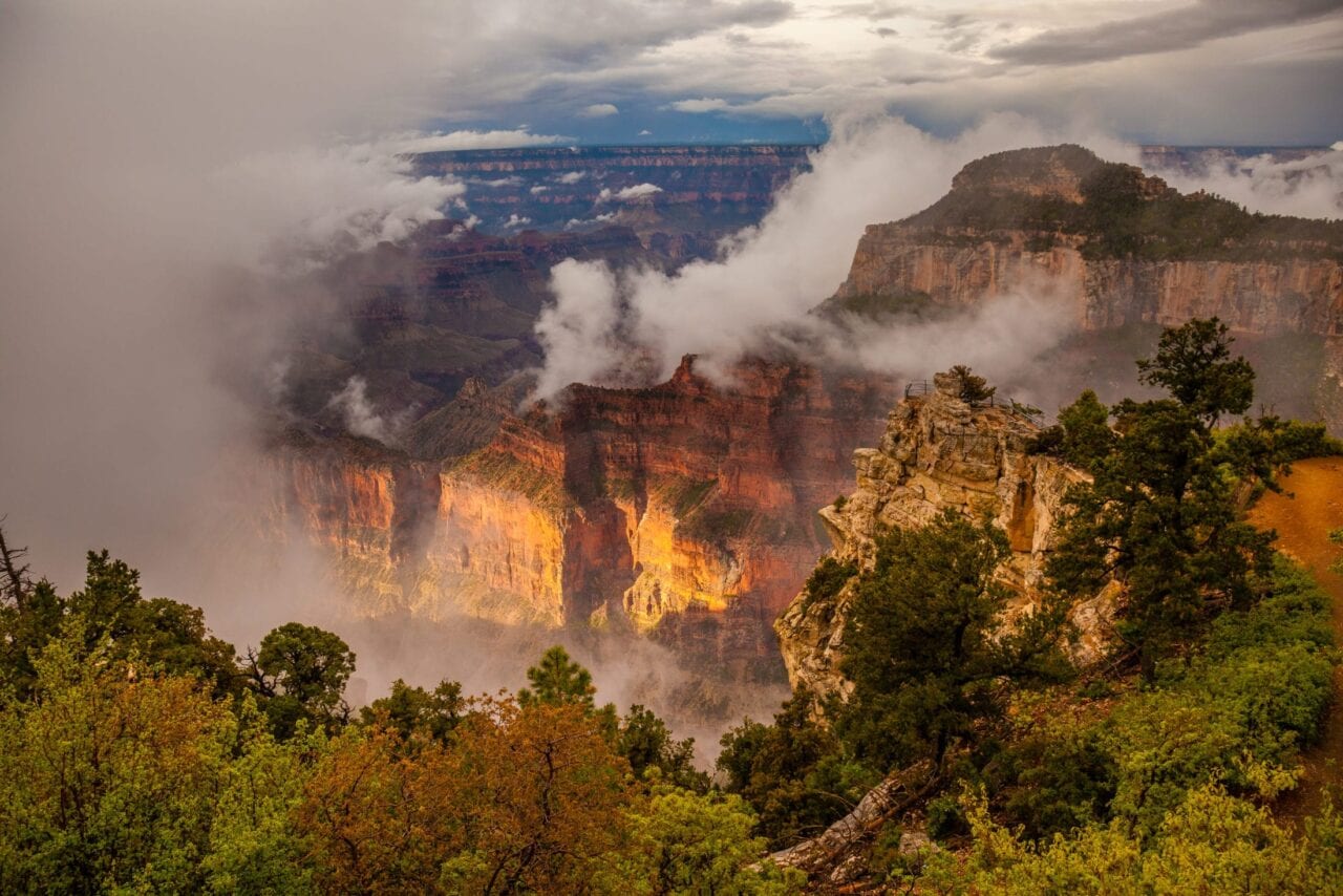 The misty Grand canyon is lit with a morning glow.