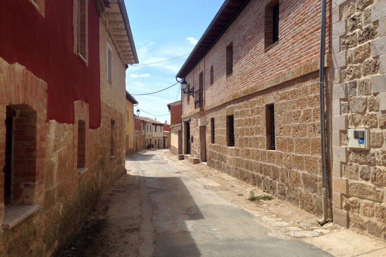 A country road winds through a town of stone buildings.
