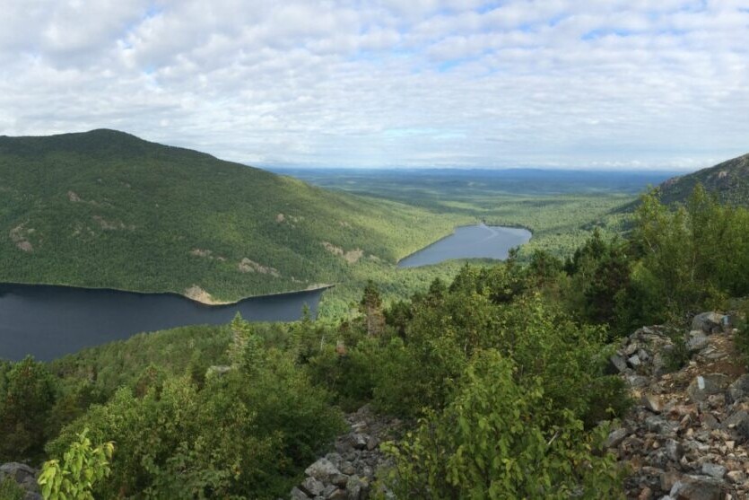 A green ridge overlooks a lake.