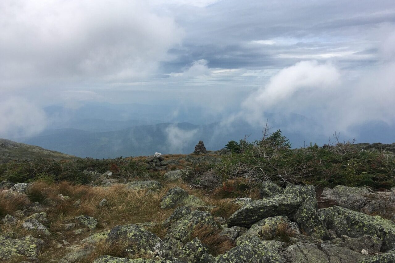 A rocky ridge overlooks a cloudy valley.