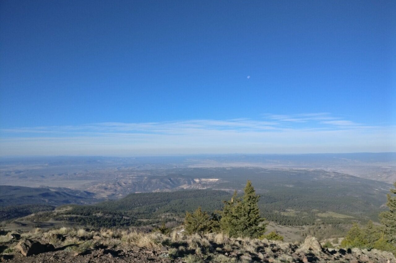 A view from a rocky ridge looks out over a valley.