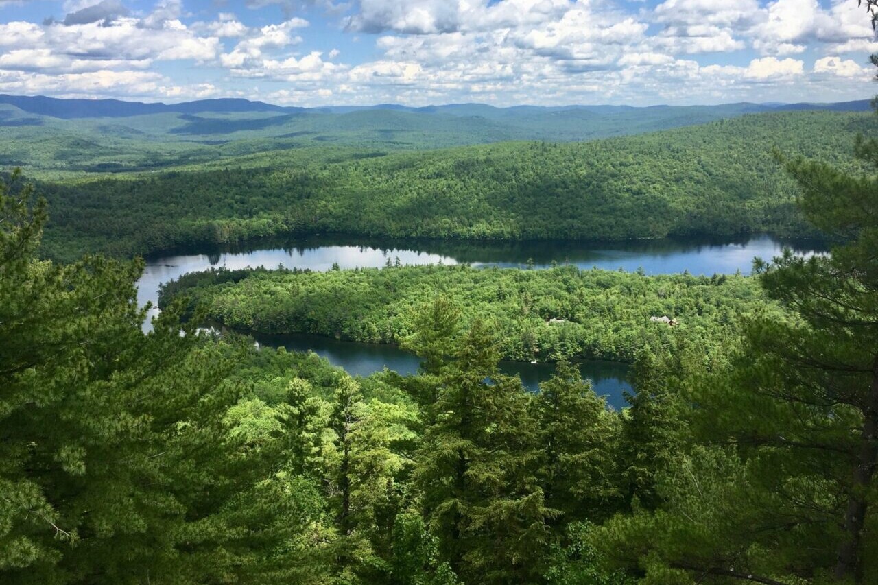 A view overlooks a lush green valley and a river.