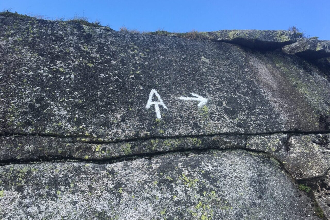 An Appalachian Trail symbol and an arrow are drawn on a rock.
