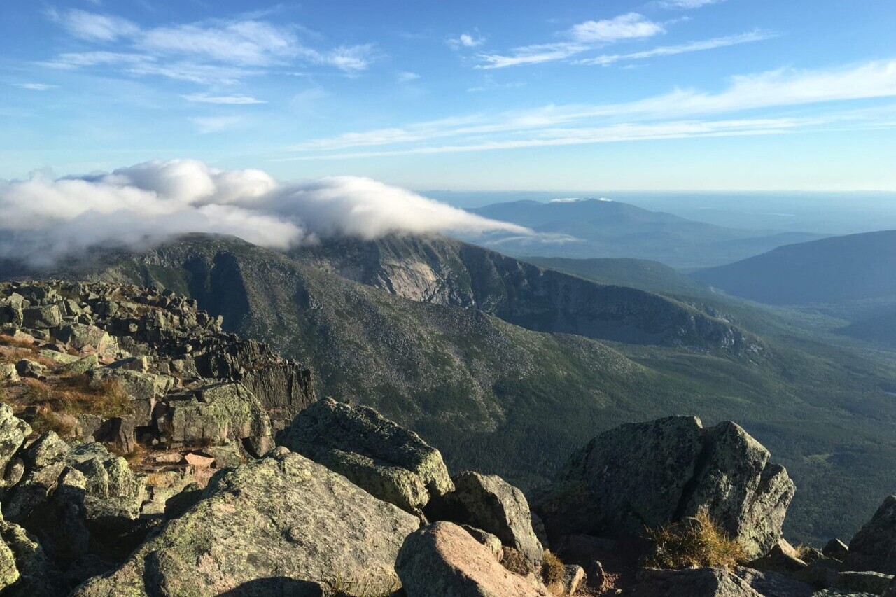 The view from Mount Katahdin shows distant mountains and rocky ridgelines.