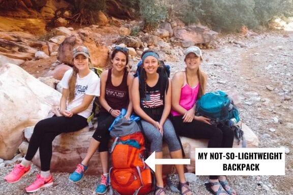Girls hiking to Havasu Falls and resting on a rock with their backpacking backpacks.