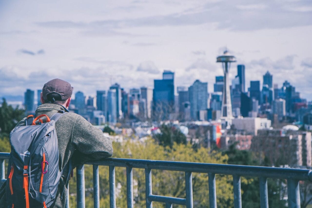Man on bridge looking at Seattle Space Needle in distance