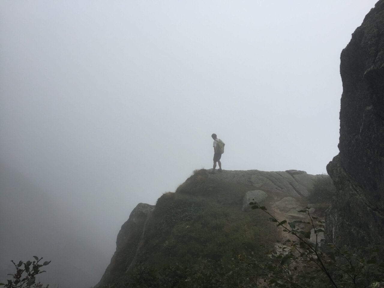Hiker in the White Mountains on a foggy ledge