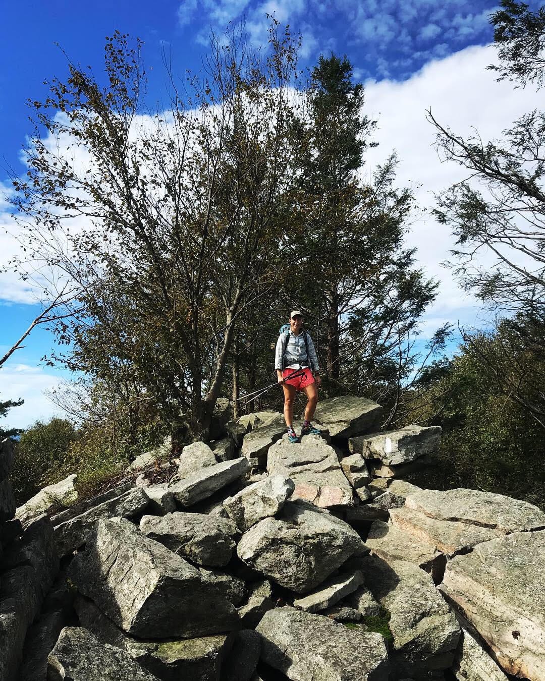 A girl hiking on some rocks.