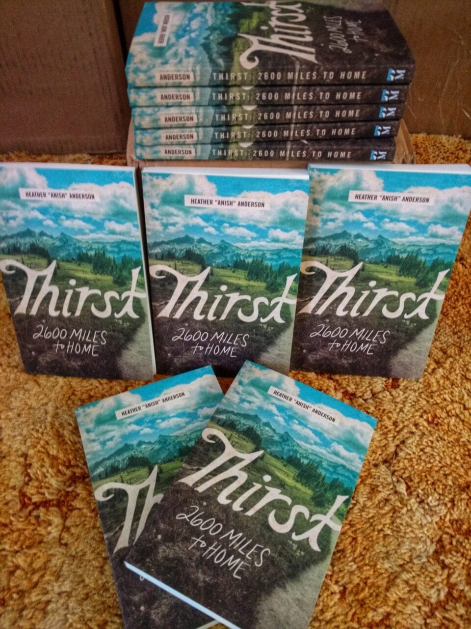 A stack of books called Thirst: 2600 miles to home by Heather Anderson.
