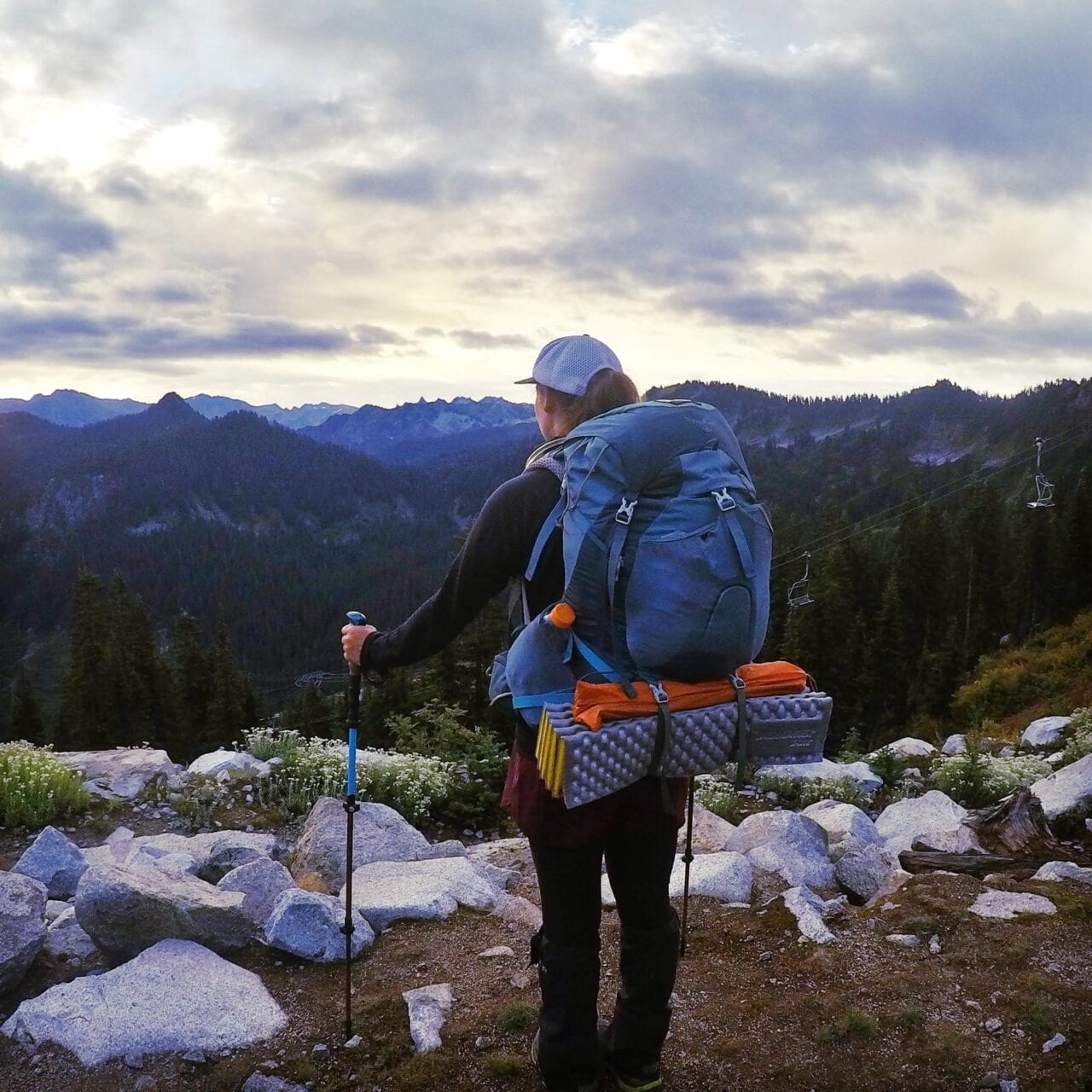 A woman hiker standing looking at the mountains.