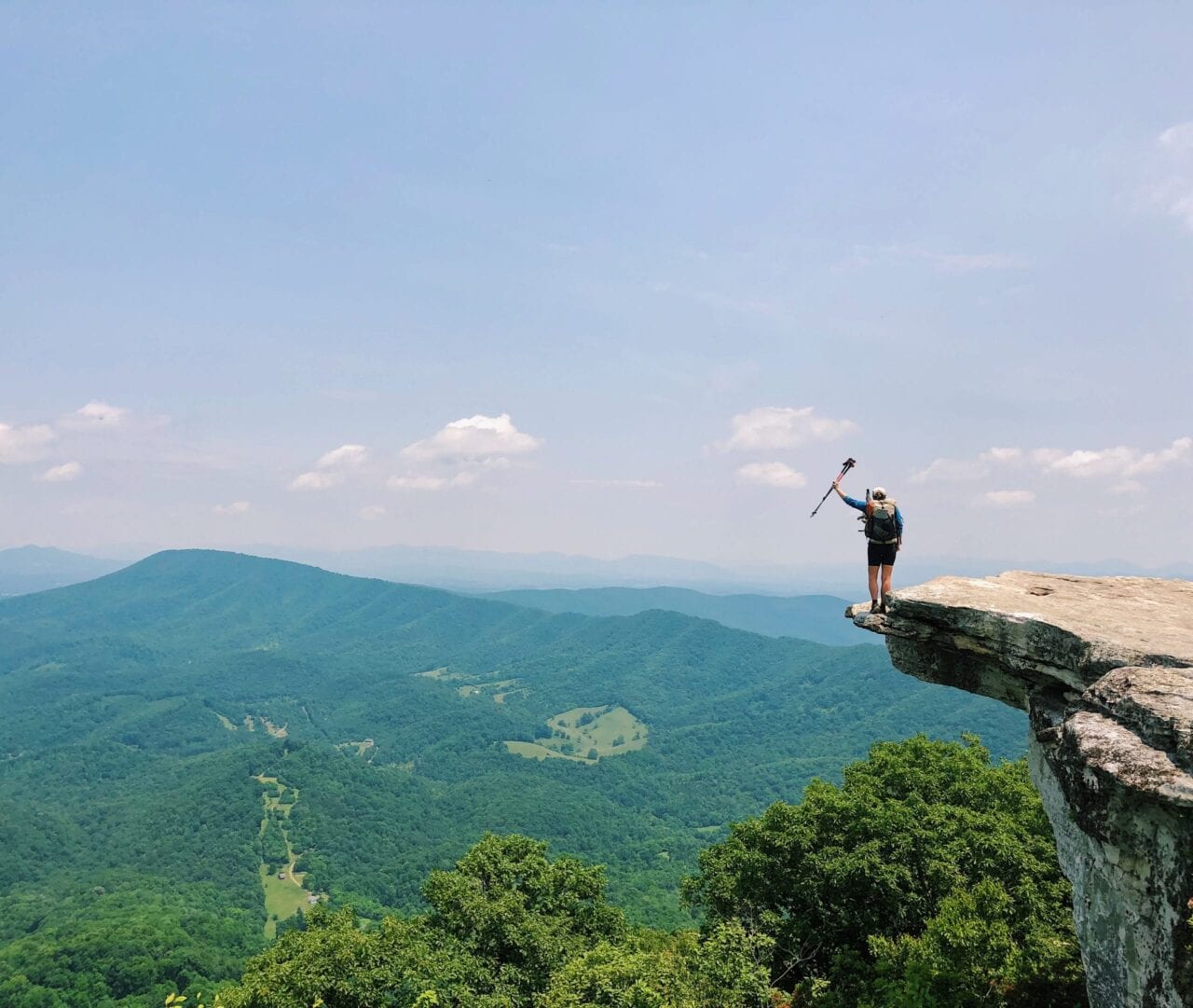 A woman standing at the edge of a rock cliff on the Appalachian Trail.