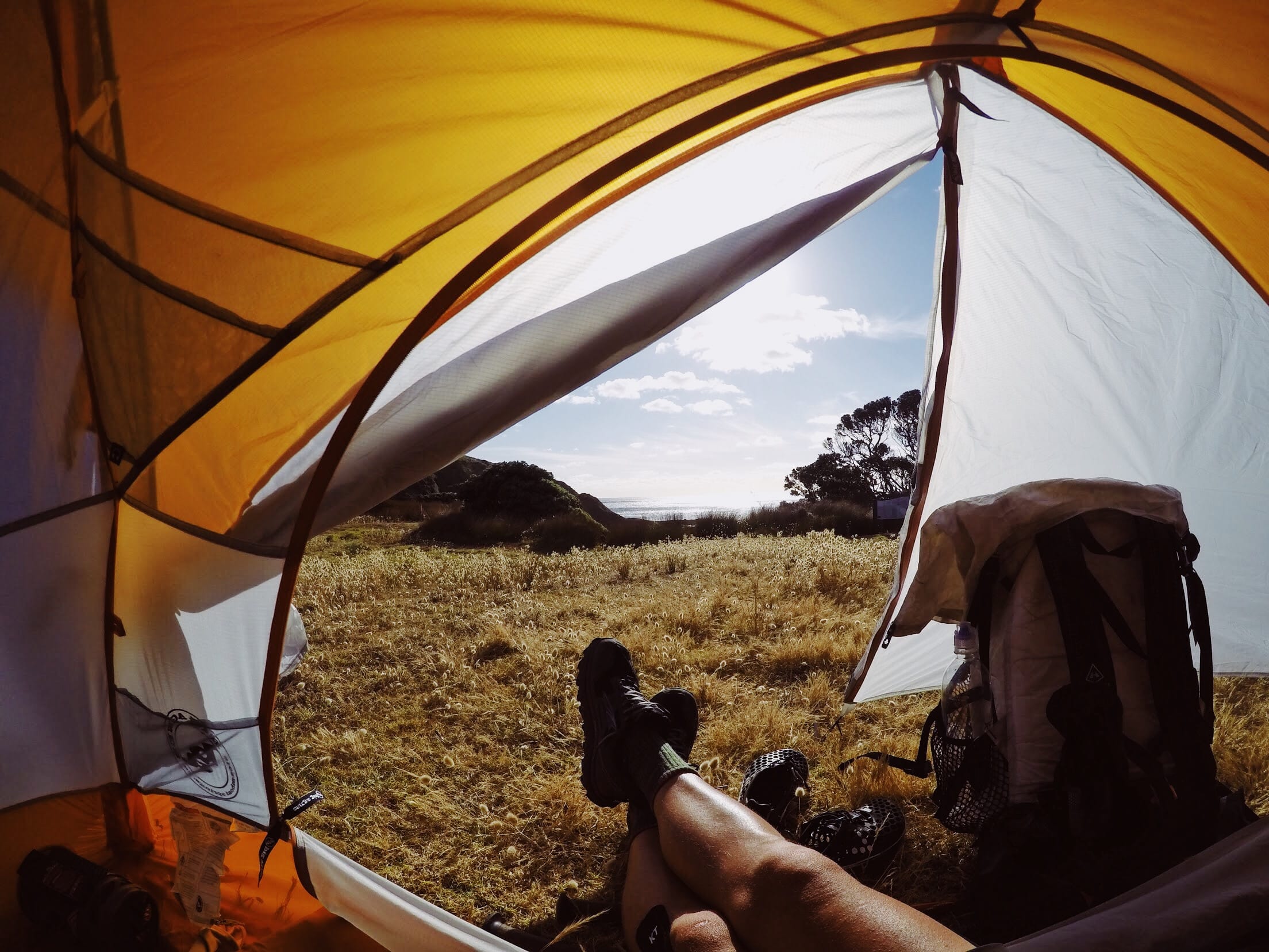 A view from sitting inside a yellow tent.