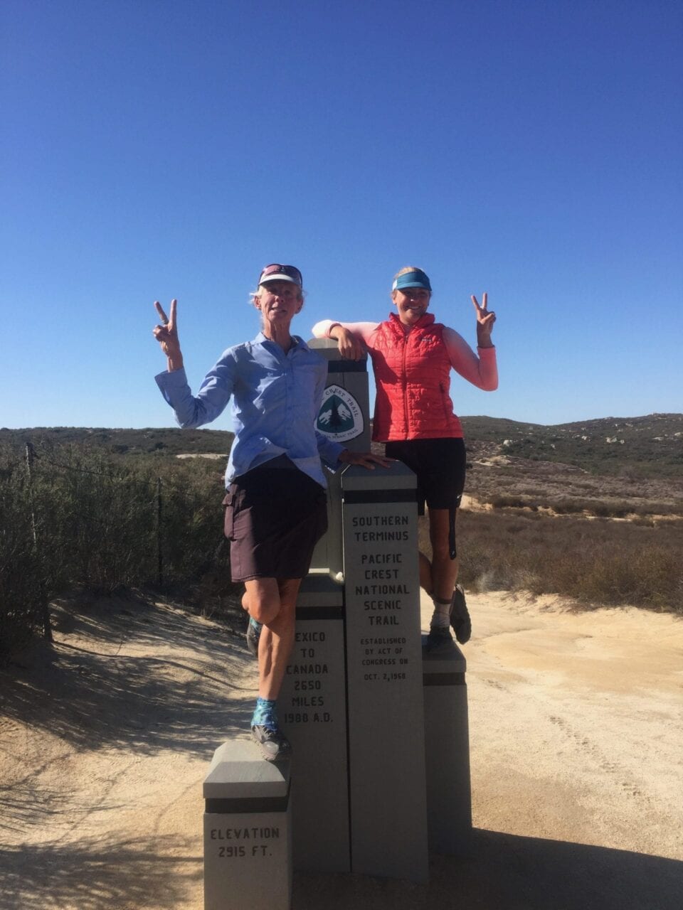 Two women standing on the southern terminus of the Pacific Crest Trail.