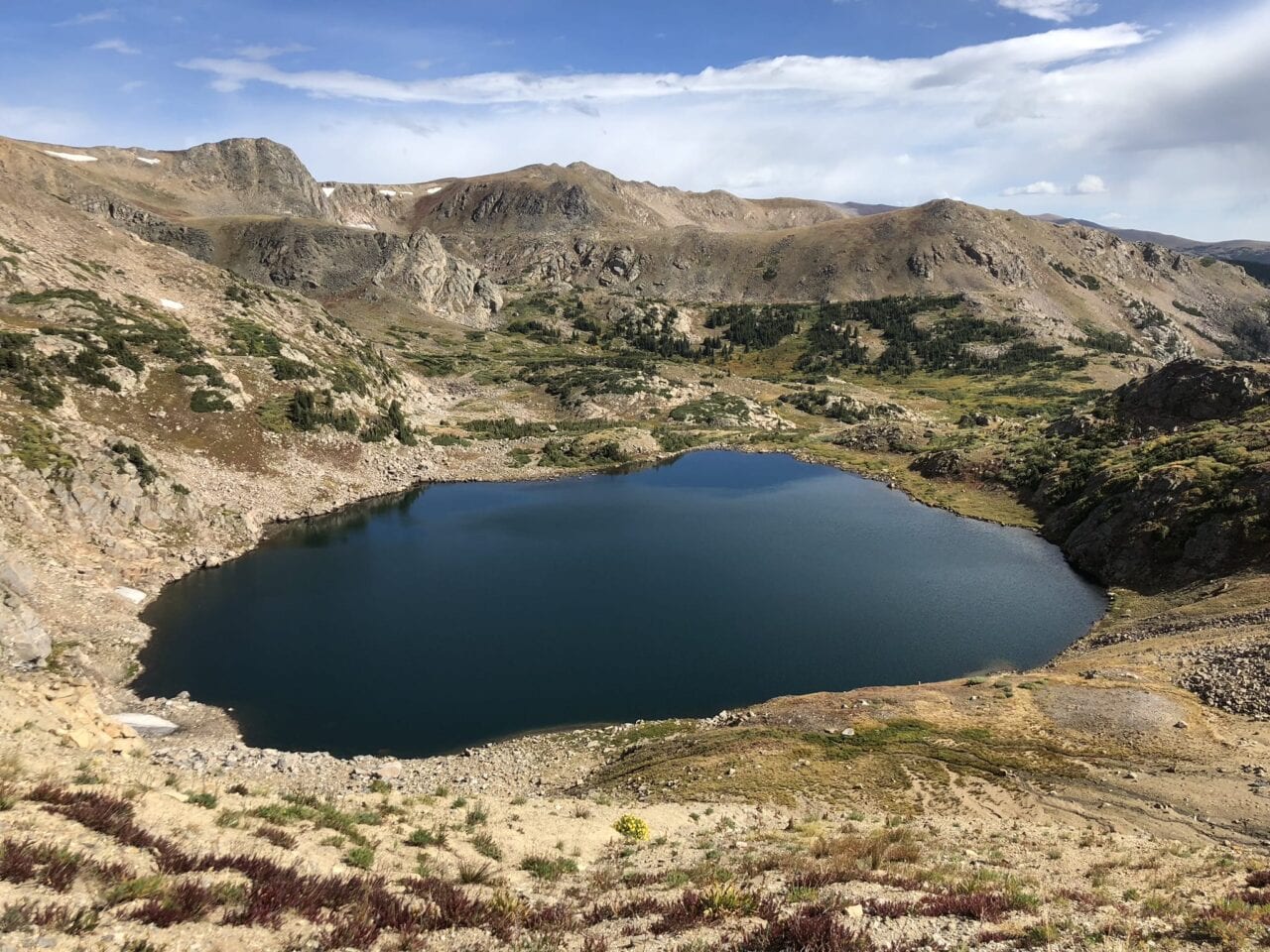 A small lake in the middle of a rocky mountain area.