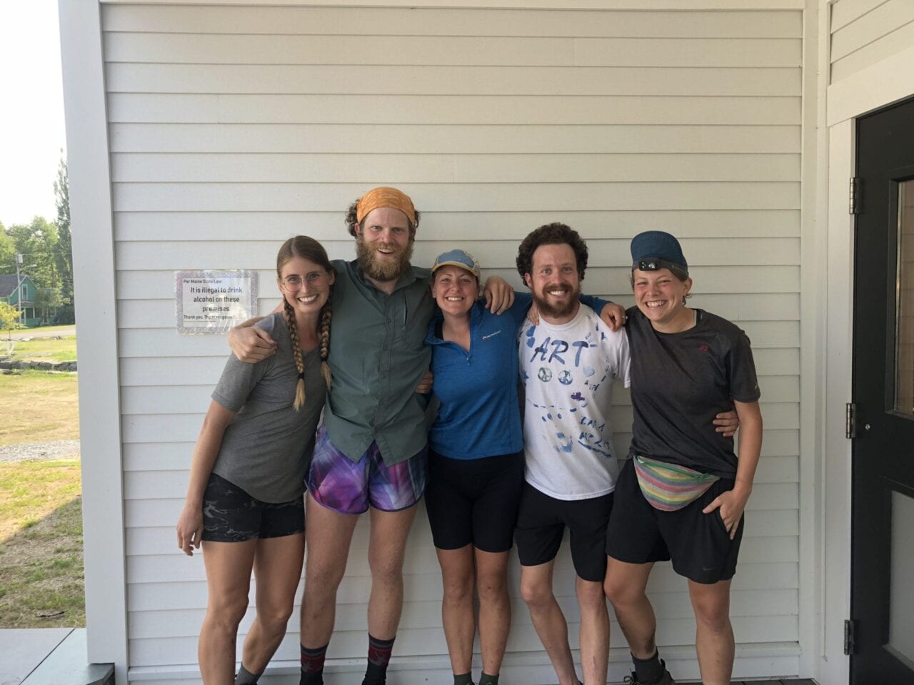 A group of hiker friends hugging.