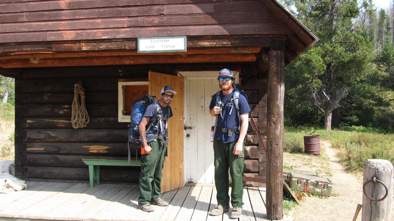 Two USFS firefighters standing at a guard station.