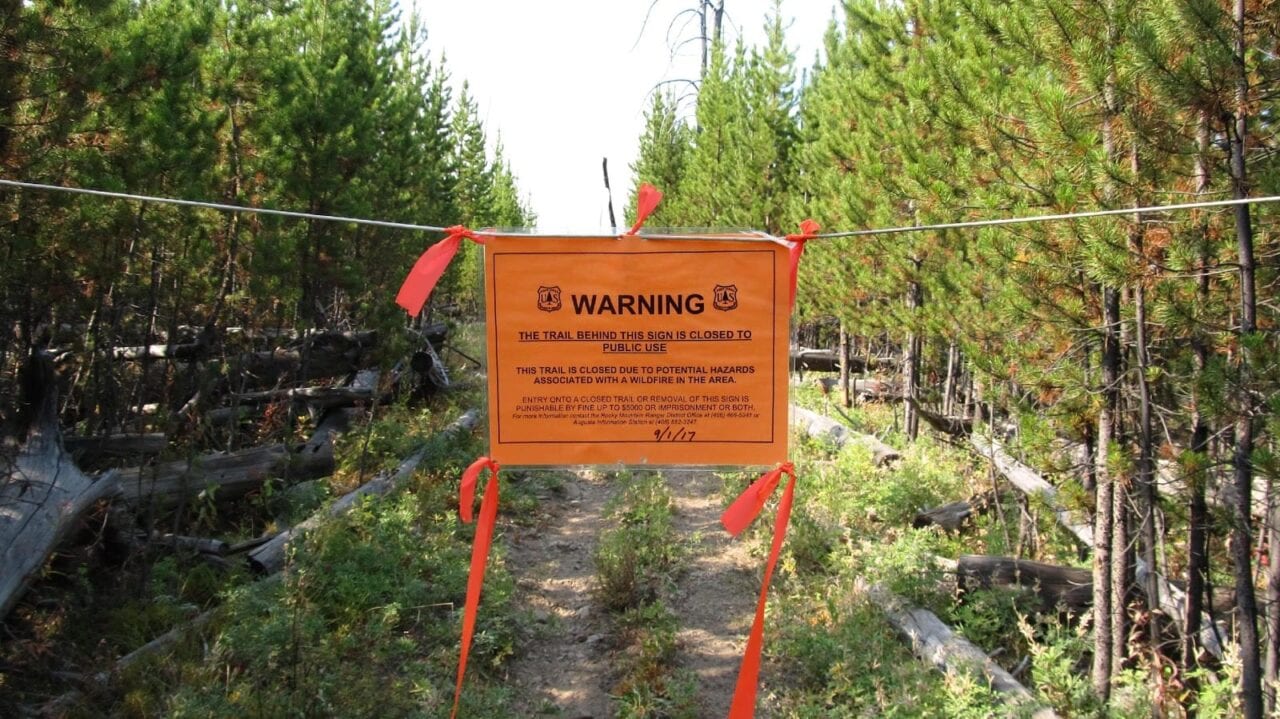 A warning sign hung to close off a trail.