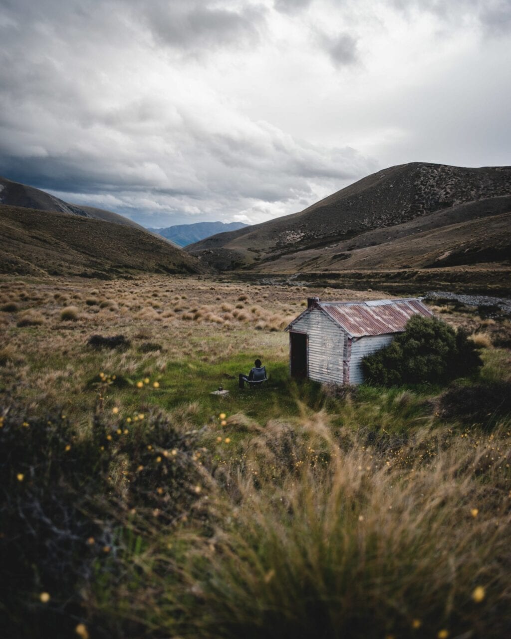 A small house on a hill in the mountains.