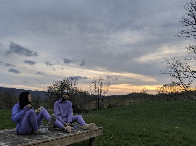 Two hikers in purple clothes sitting.