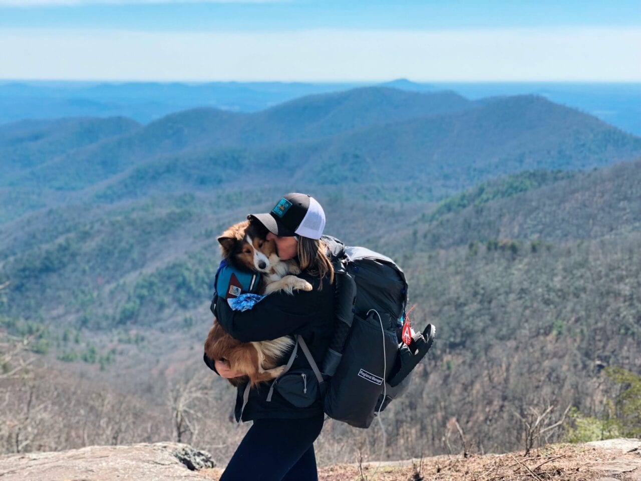 A girl hugging her dog on the Appalachian Trail.