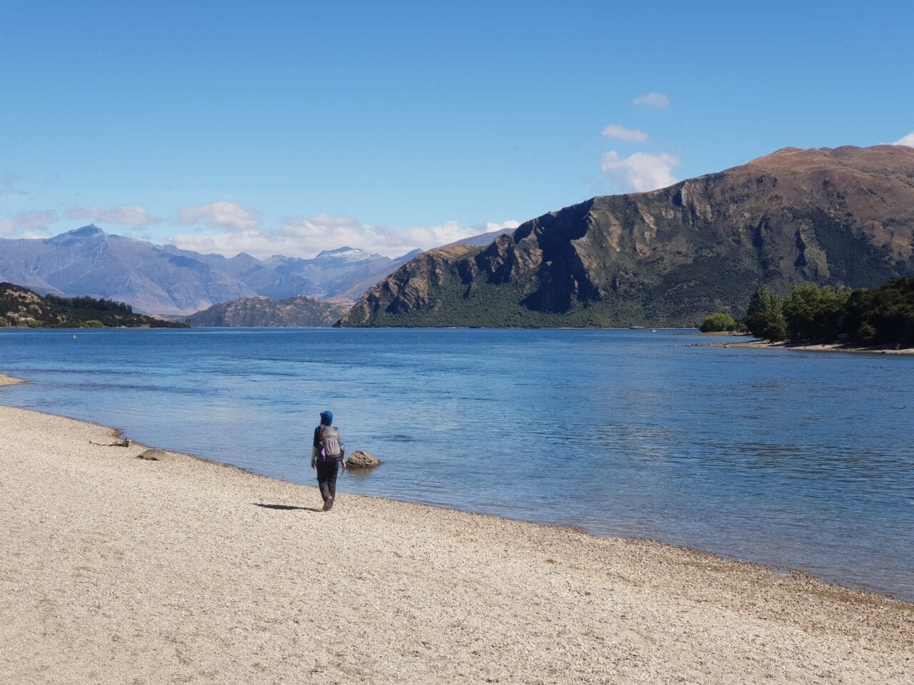 A hiker standing next to a lake on the Te Araroa.