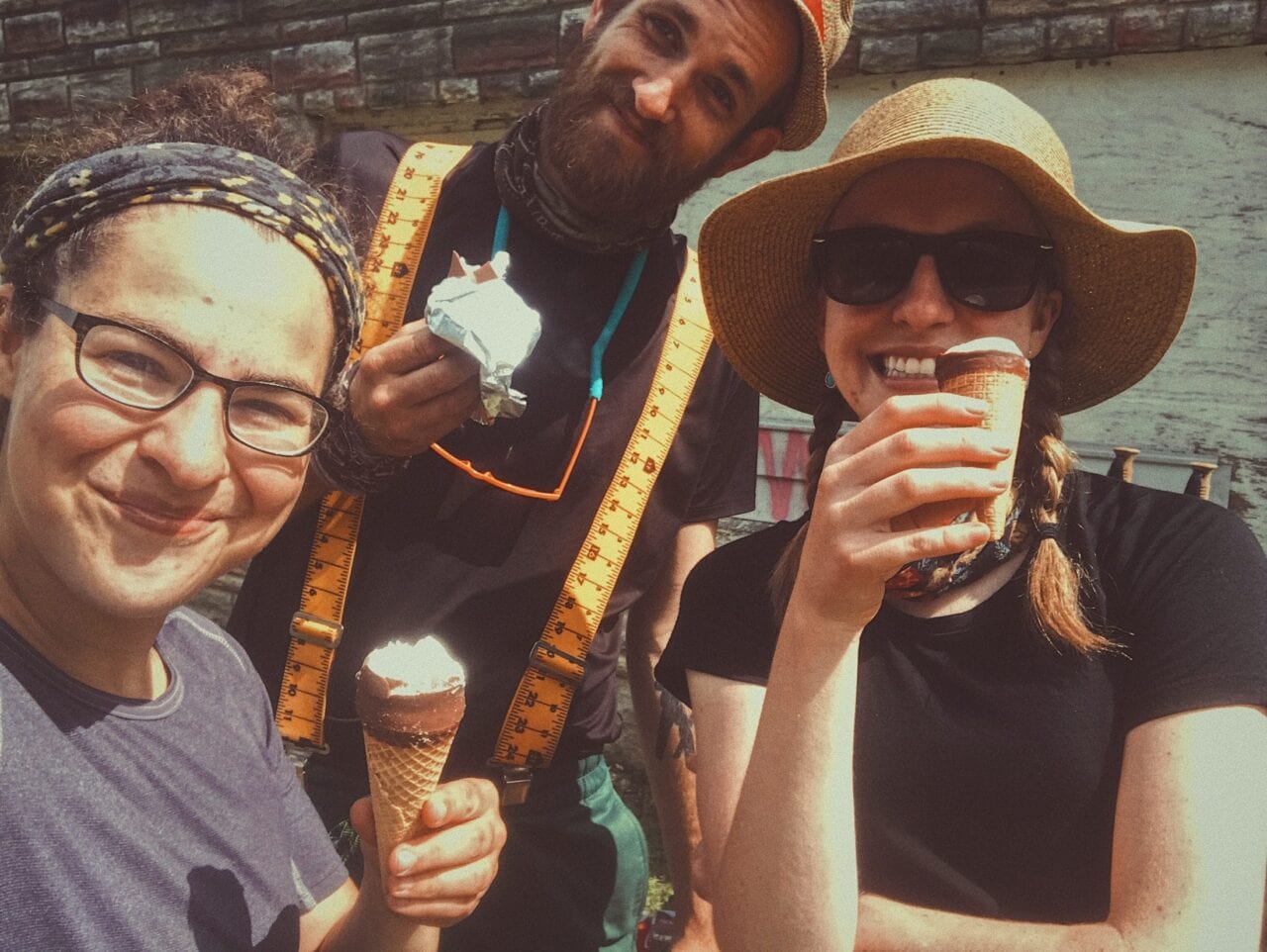 Hikers smile holding ice cream.