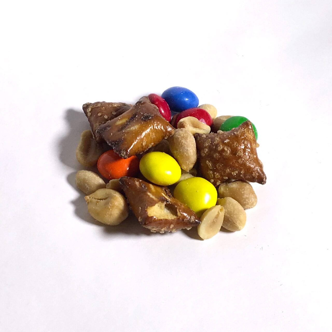 A pile of GORP trail mix including nuts and m&ms.