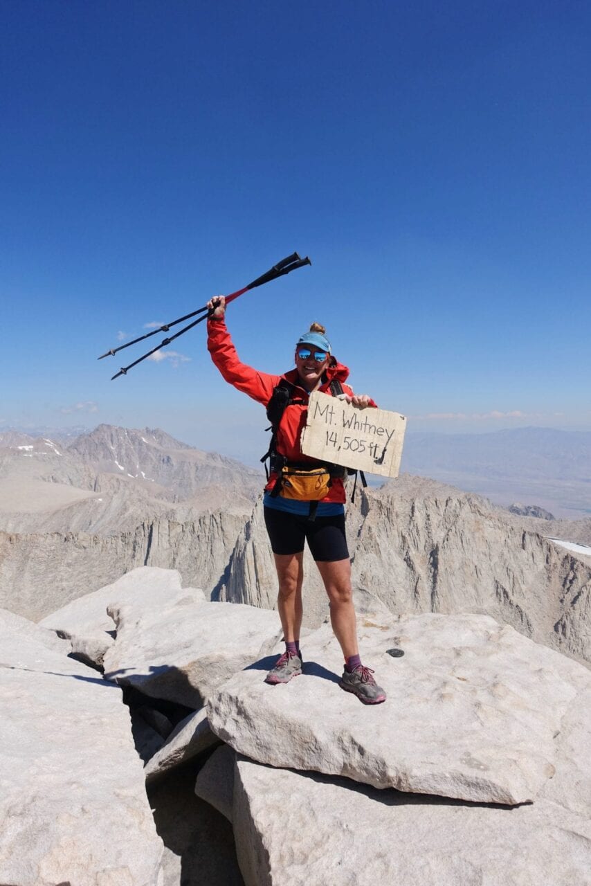 A hiker standing on the top of Mount Whitney.