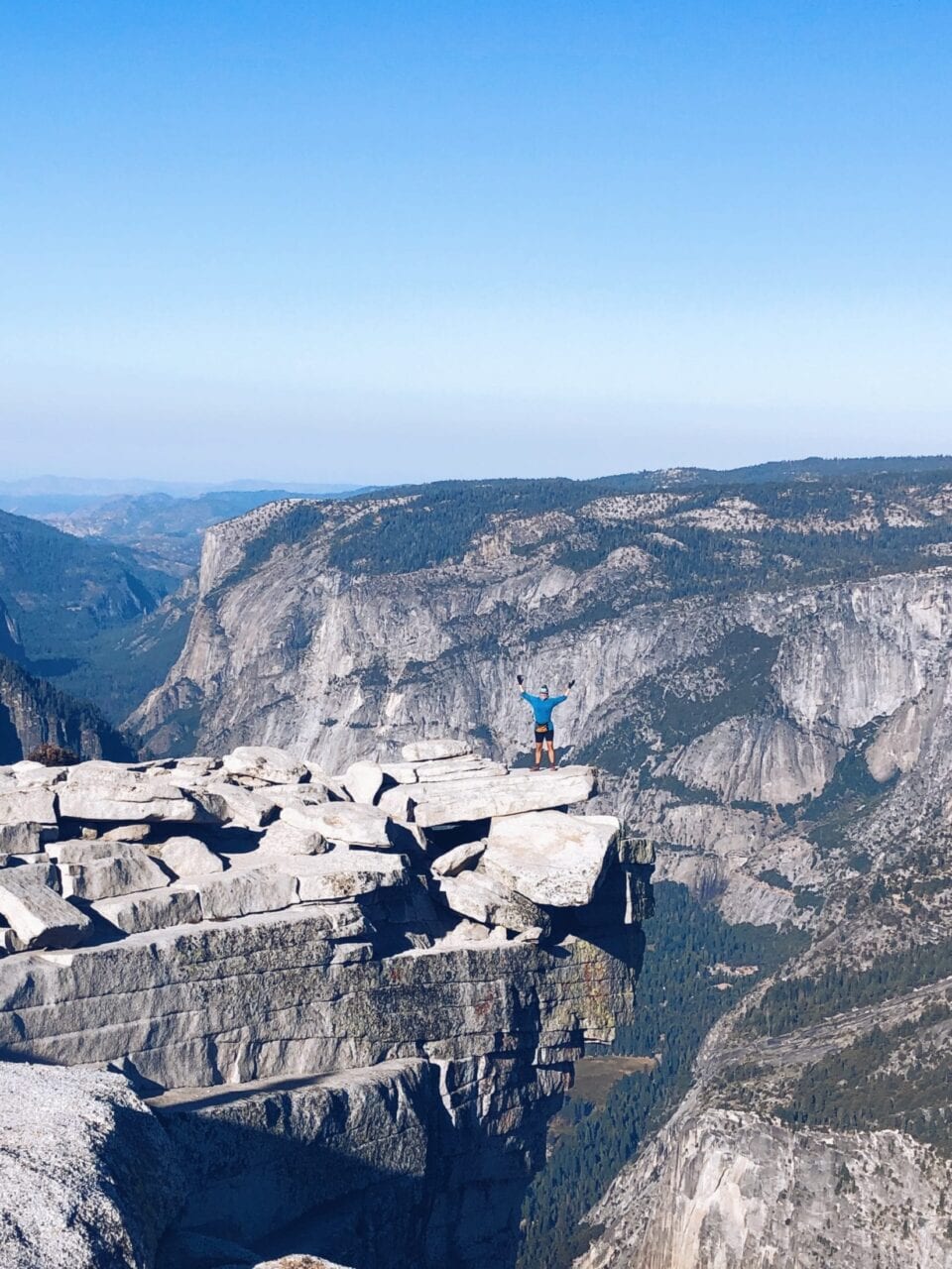 A hiker standing on a mountain edge on the John Muir Trail.