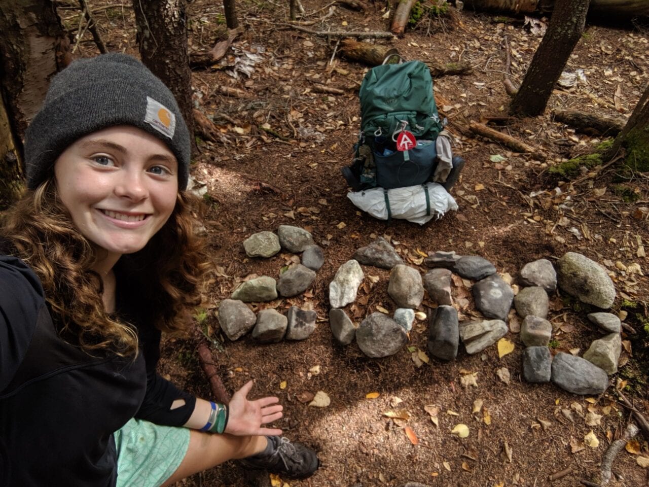 Thru-hiker with 2000 spelled out on the ground next to them on the Appalachian Trail