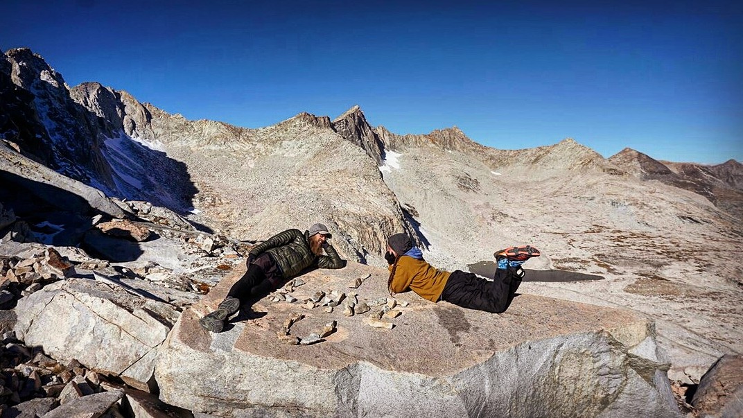 Hikers laying out on a rock.