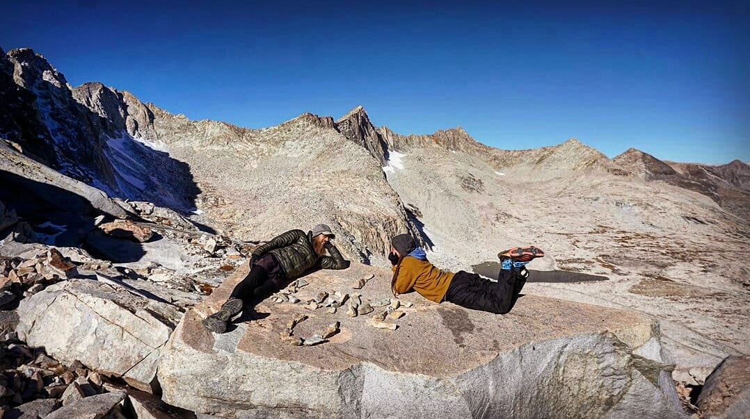Hikers laying out on a rock.
