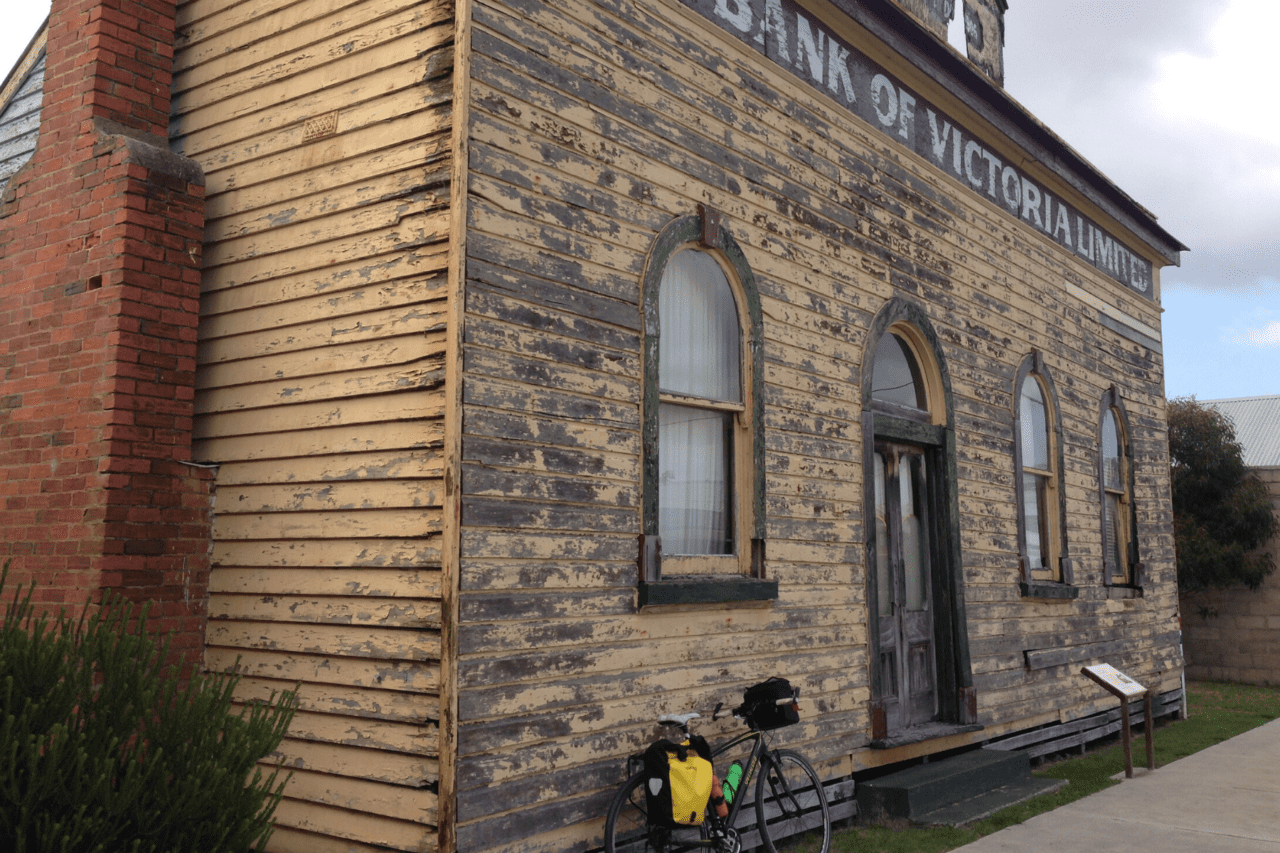 A bike propped up against an old building.
