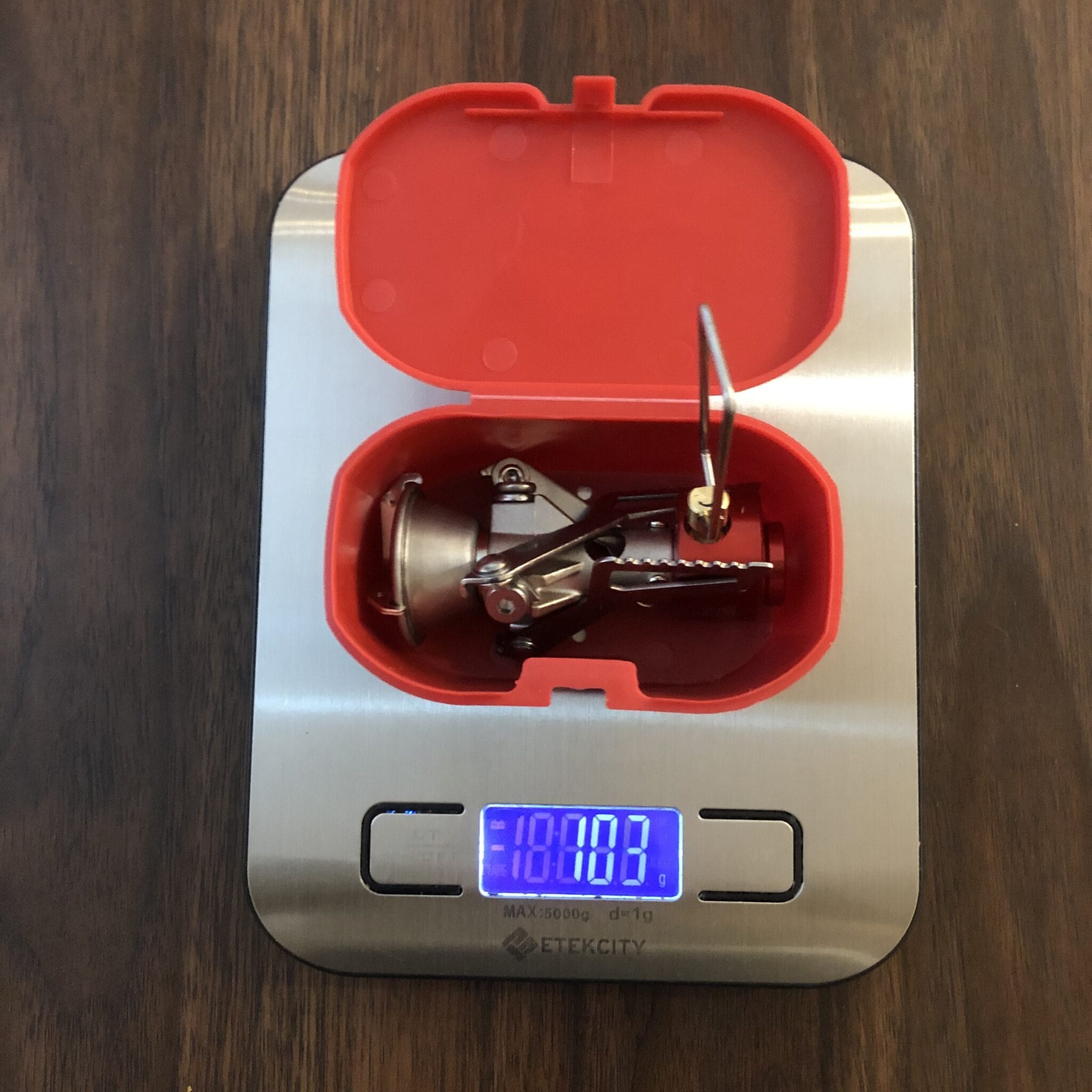 The MSR PocketRocket 2 in its case being weighed on a scale.