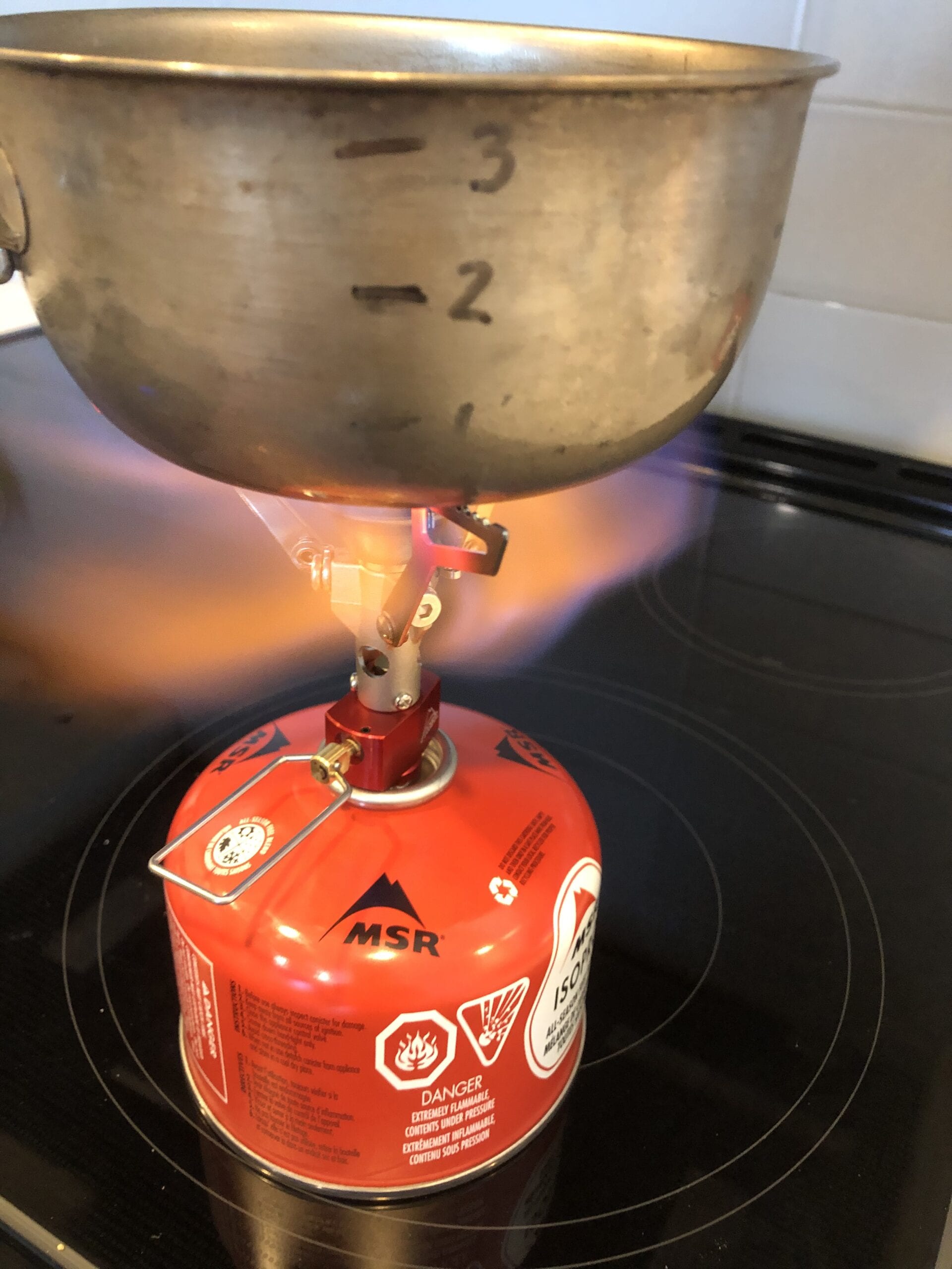 The MSR PocketRocket 2 Stove attached to a fuel canister boiling a pot of water.