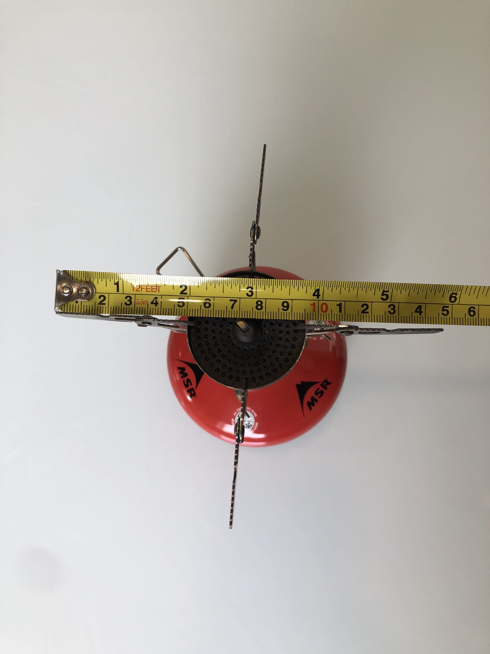 Soto WindMaster Stove attached to a fuel canister measure with a ruler
