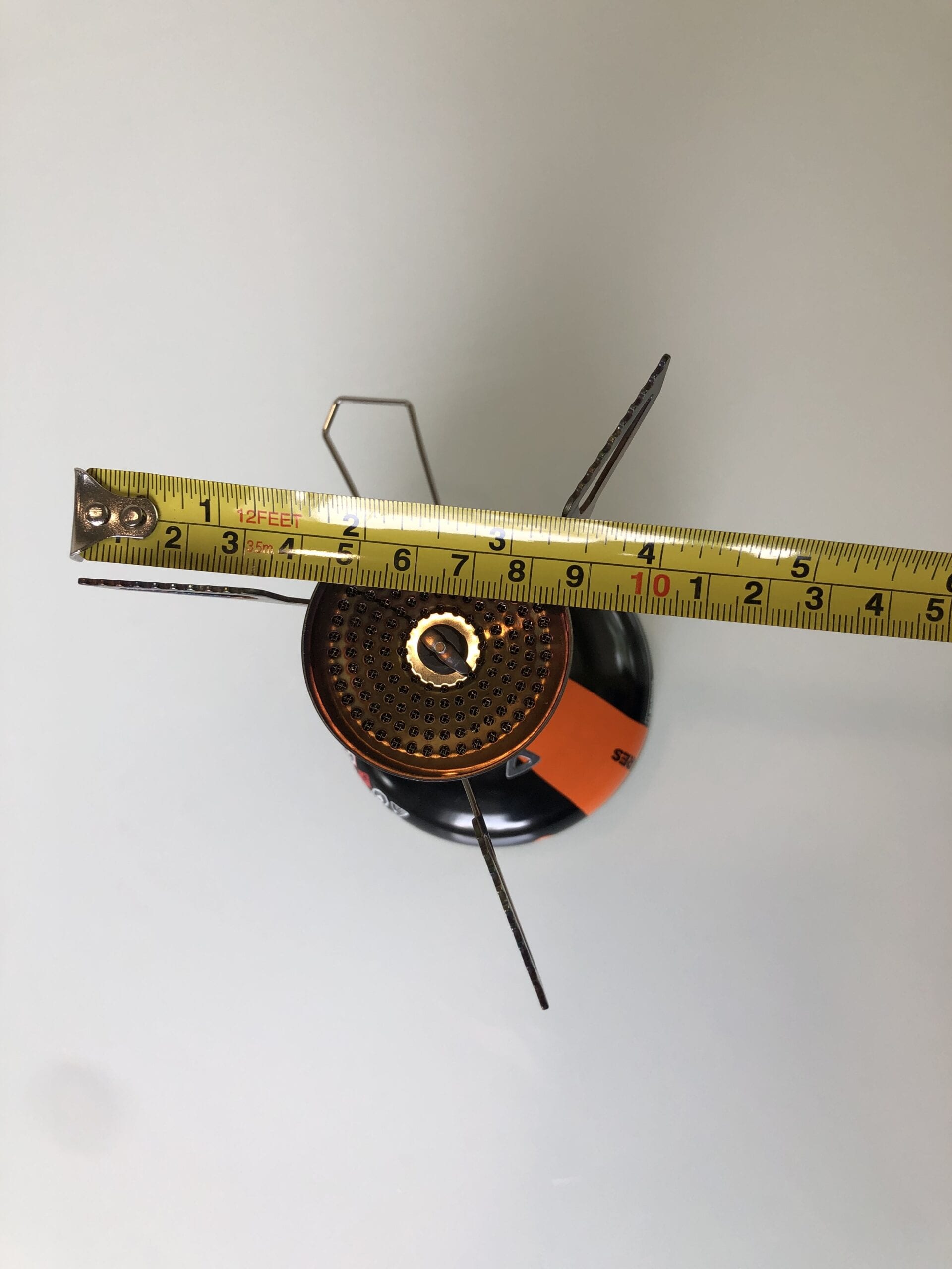 MSR PocketRocket Deluxe attached to a fuel canister being measured with a ruler.