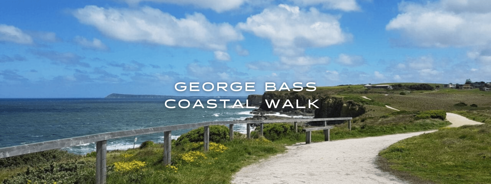 A walkway through a coastal grassy knoll with the sea visible to the left.