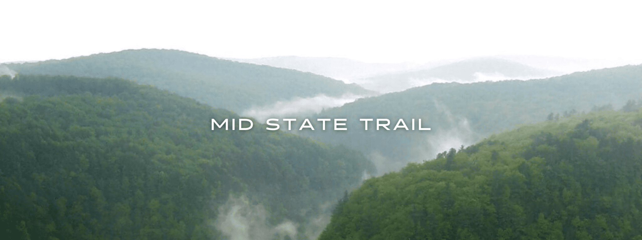 Fog covers green mountains in a view from Pennsylvania's Mid State Trail.