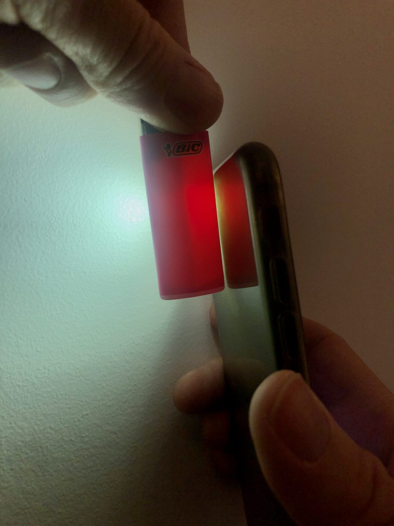 A phone flashlight shining on a BIC mini lighter.