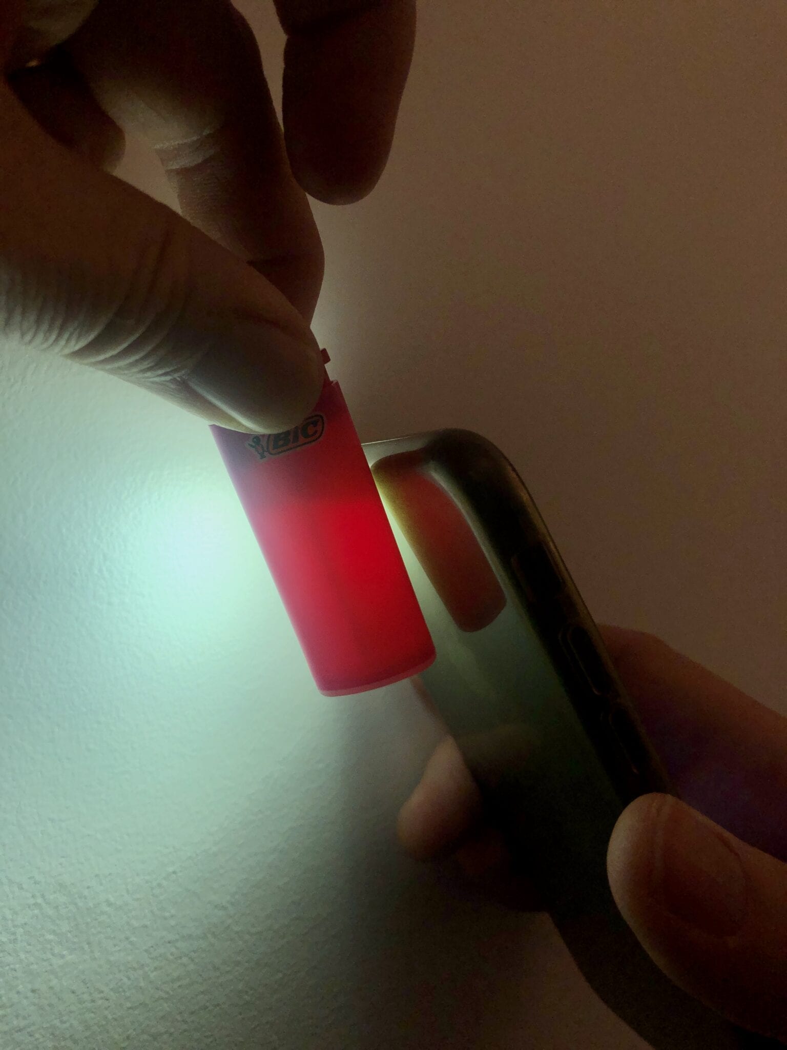 A phone flashlight shining on a BIC mini lighter.