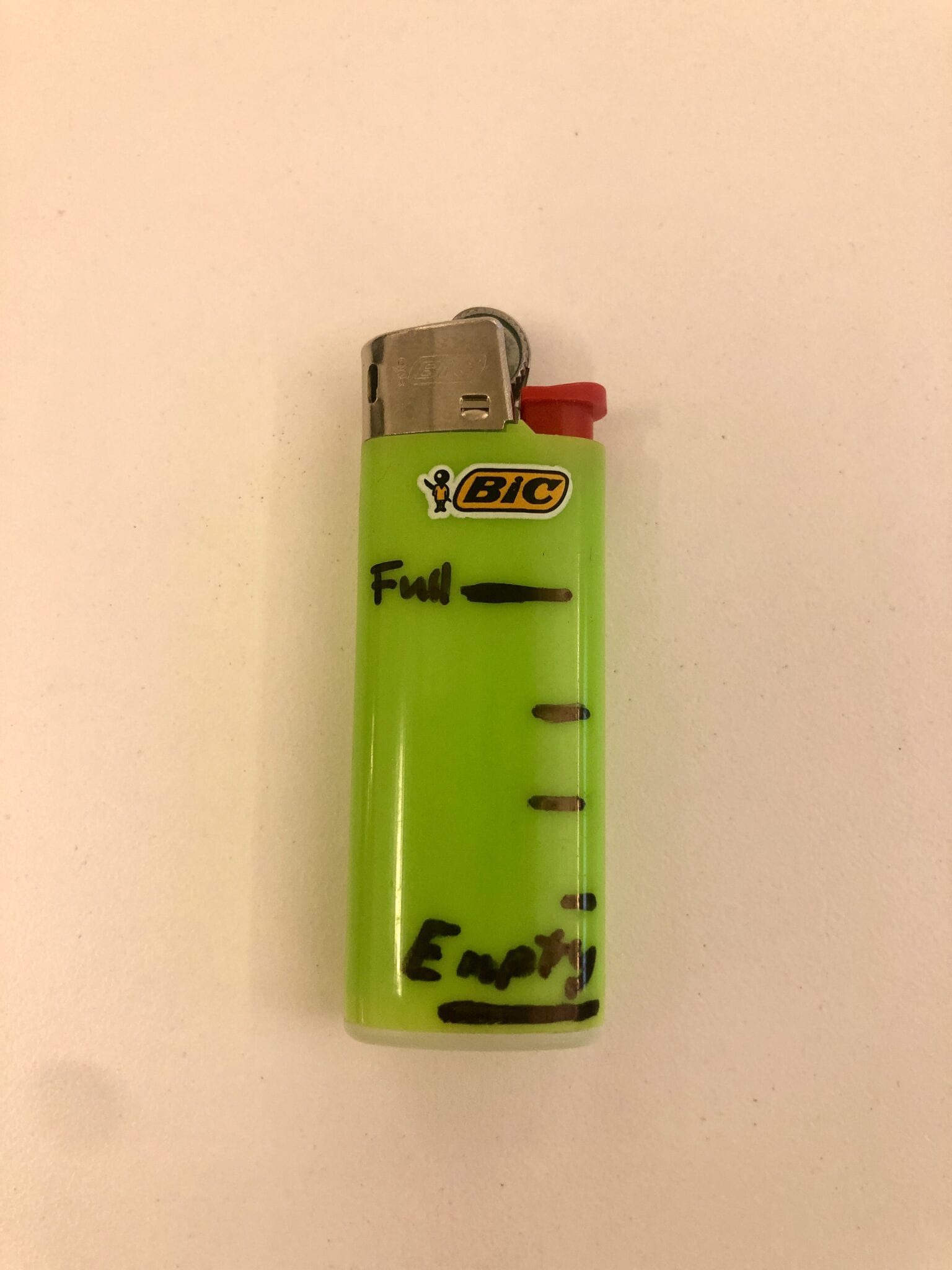A BIC Mini lighter with markings drawn on it for fuel measurements.