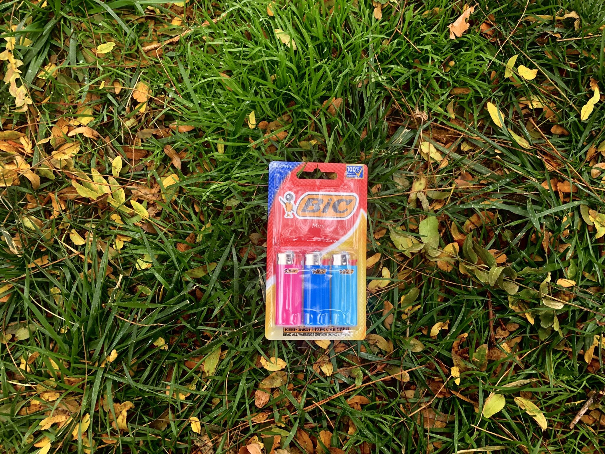 A pack of 3 BIC Mini lighters in the grass.