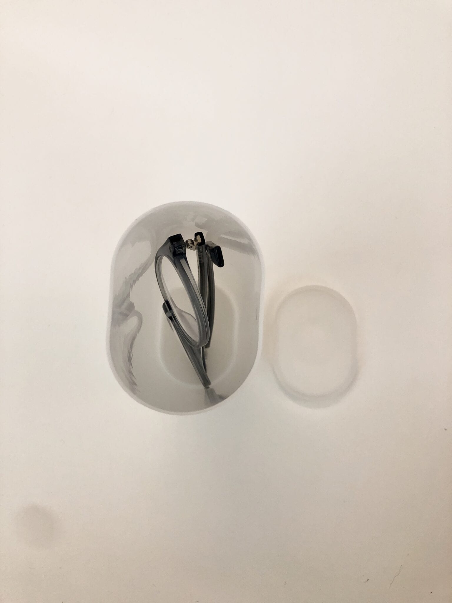 A pair of glasses inside a Crystal Light container.