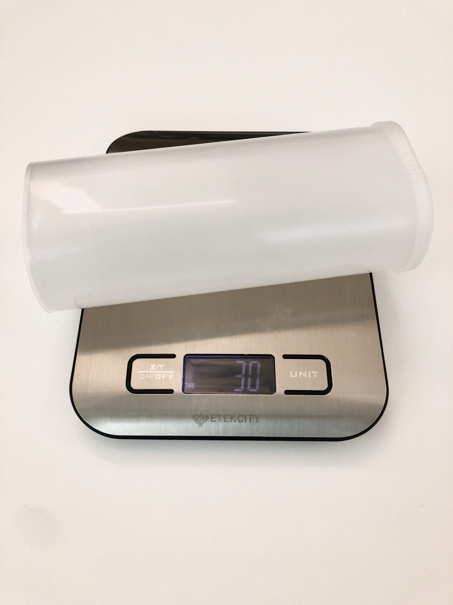A Crystal Light container being weighed on a small scale.