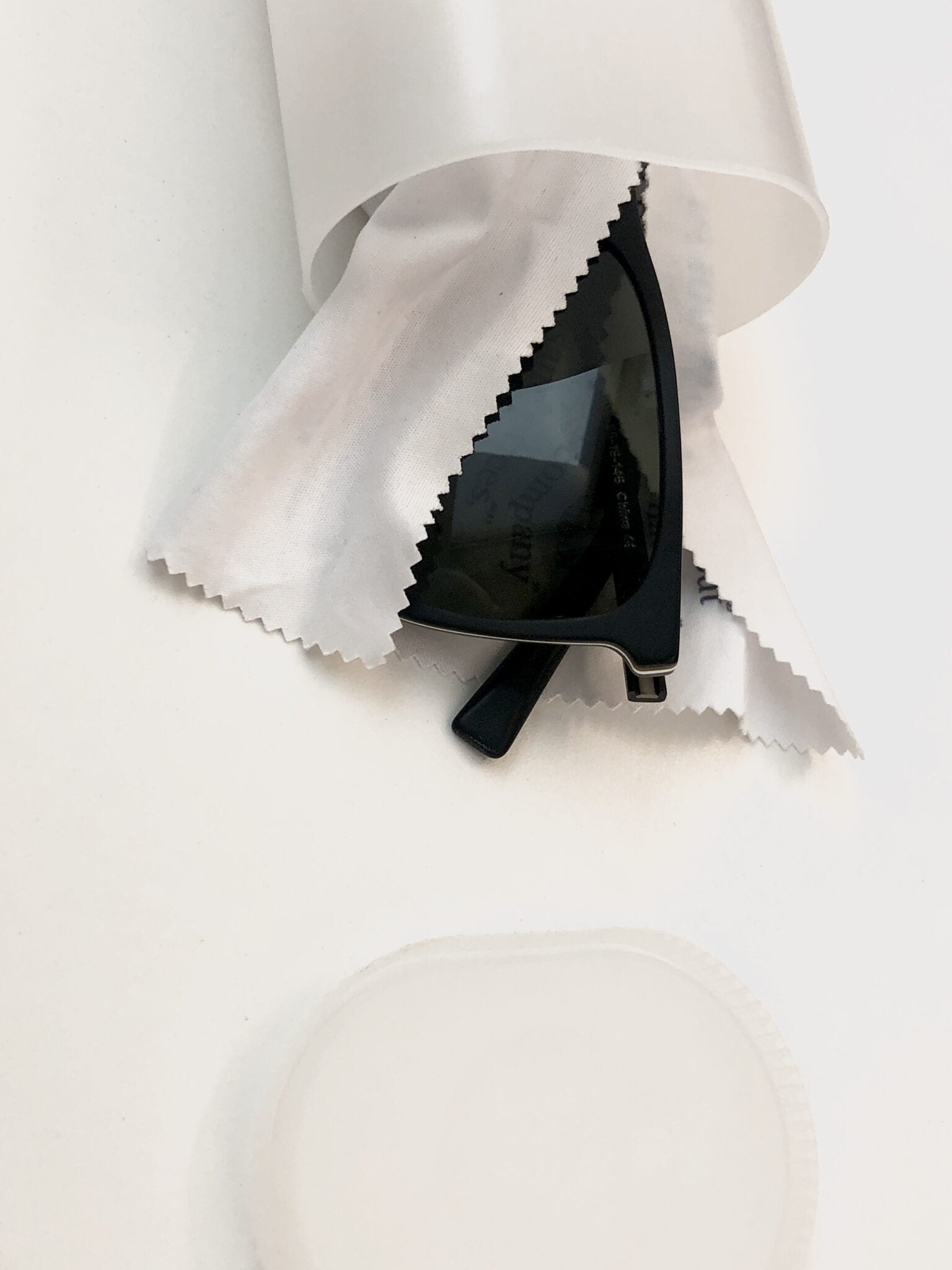 A pair of sunglasses wrapped in a cloth inside a Crystal Light container.