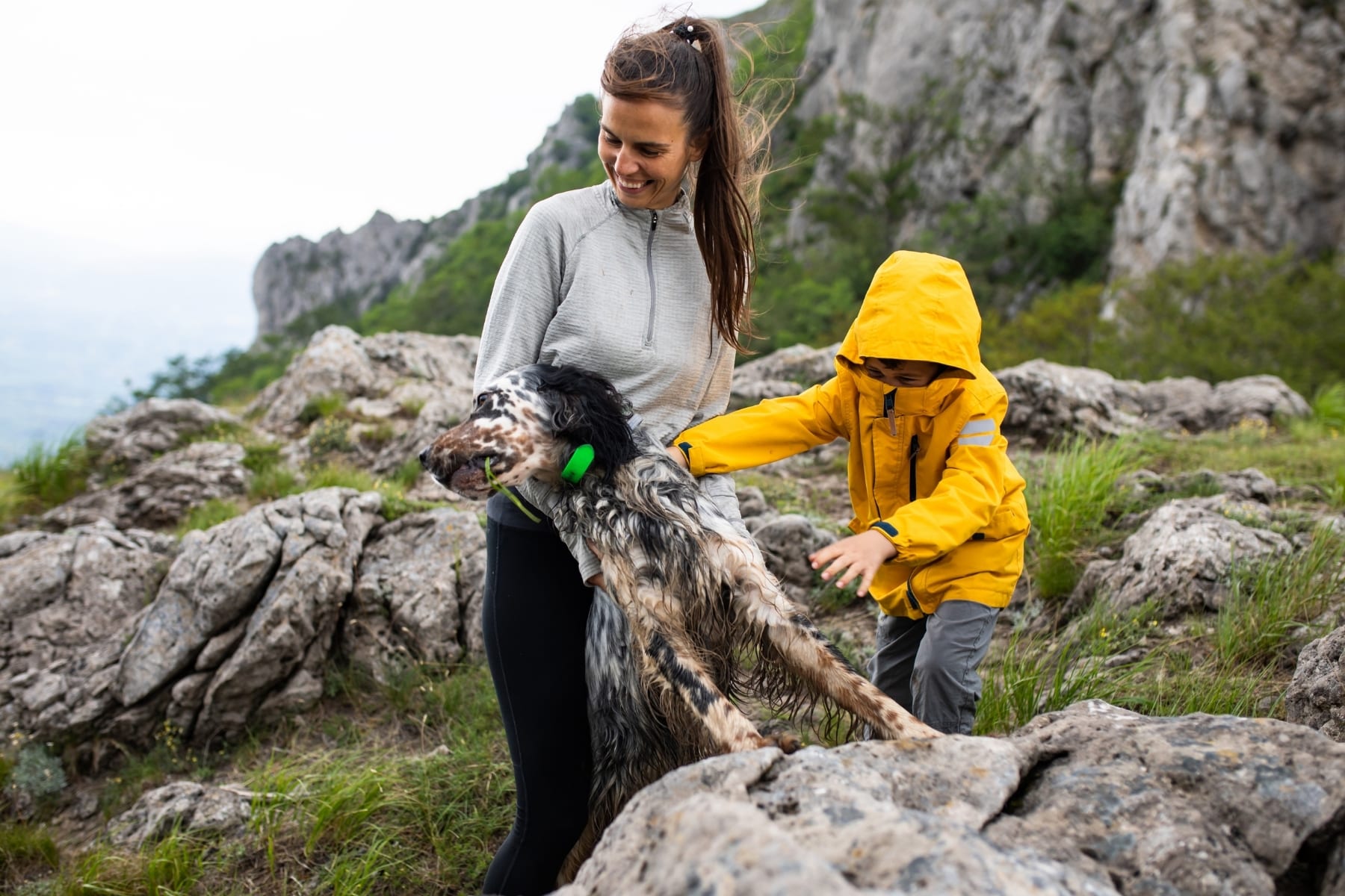 A mom and her son and dog outside on a hike
