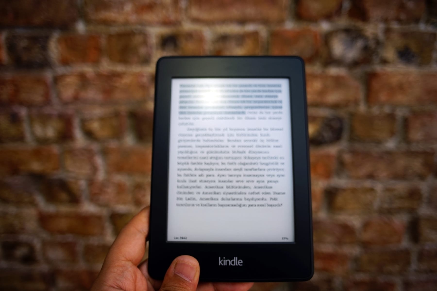 A hand holding a kindle.
